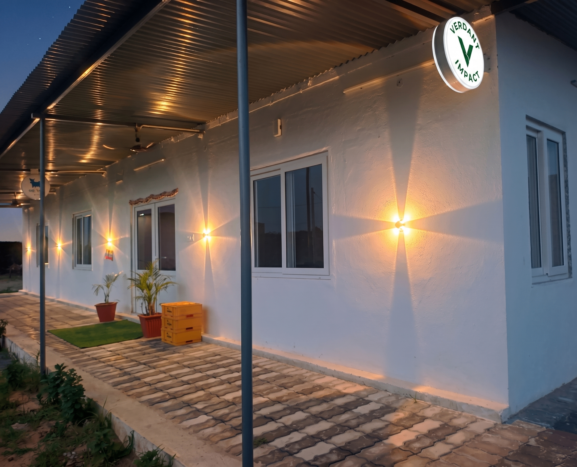 Verdant Impact farm facility at dusk with branded signage